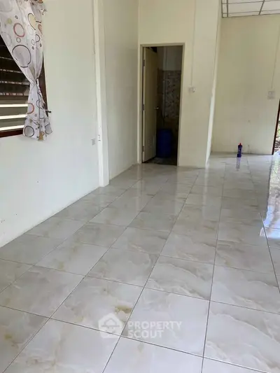 Spacious interior with tiled flooring and natural light, ideal for customization.