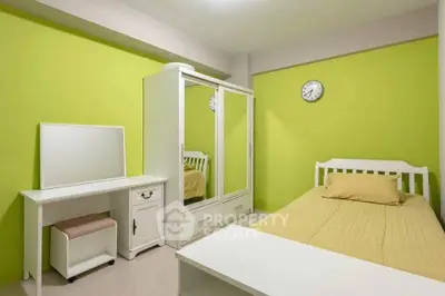Cozy bedroom with vibrant green walls and white furniture, featuring a mirrored wardrobe and a stylish vanity.