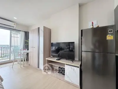 Modern living room with balcony view, featuring sleek TV unit and stainless steel fridge.