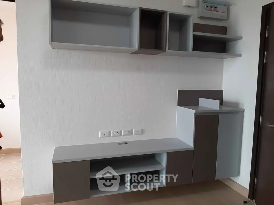 Modern minimalist living room with sleek built-in storage and neutral tones.
