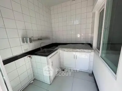 Compact kitchen with white tiled walls and minimalist design
