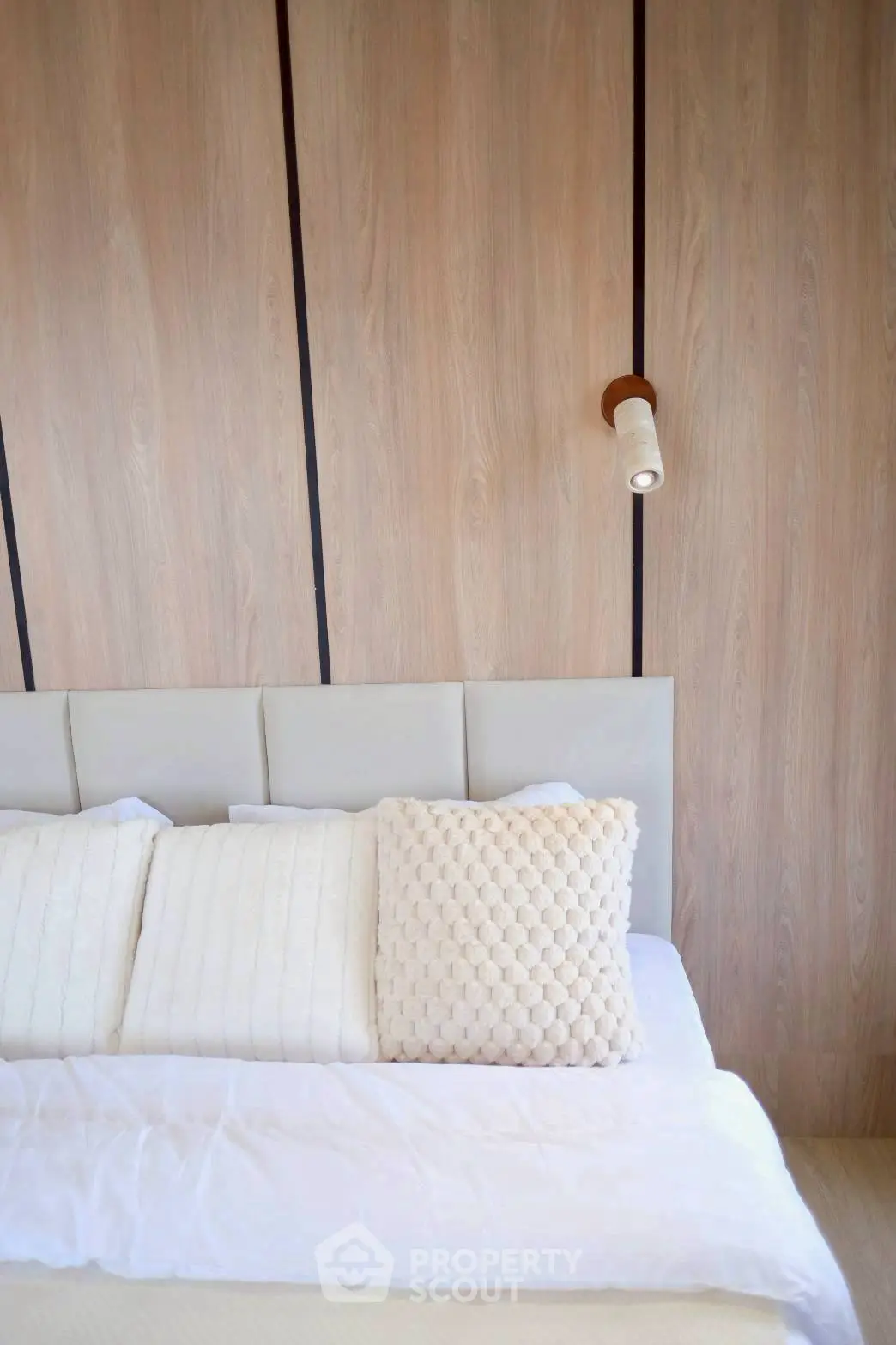 Elegant bedroom with modern wood paneling and cozy bedding