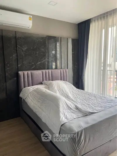 Modern bedroom with stylish decor and large window for natural light