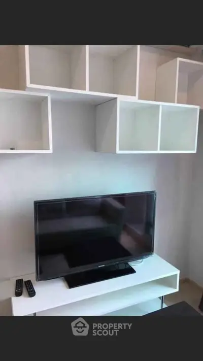 Modern living room with sleek TV setup and stylish shelving unit.