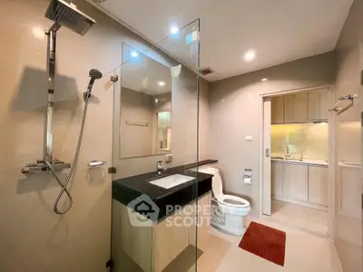 Modern bathroom with glass shower and sleek fixtures in a contemporary apartment.