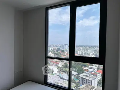 Bright and airy high-rise bedroom with expansive windows offering a panoramic city view, perfect for urban living enthusiasts.