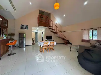 Spacious open-plan living room with modern staircase and dining area