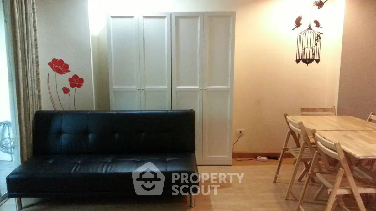 Chic living room with modern black sofa and stylish dining area, perfect for urban living.