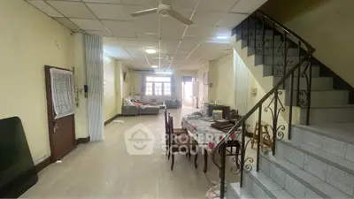 Spacious living room with dining area and staircase in a cozy home