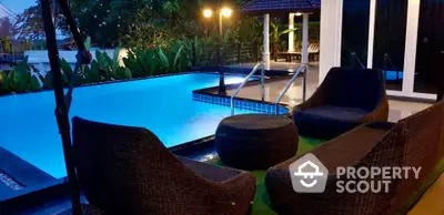 Luxurious outdoor pool area with stylish seating and ambient lighting