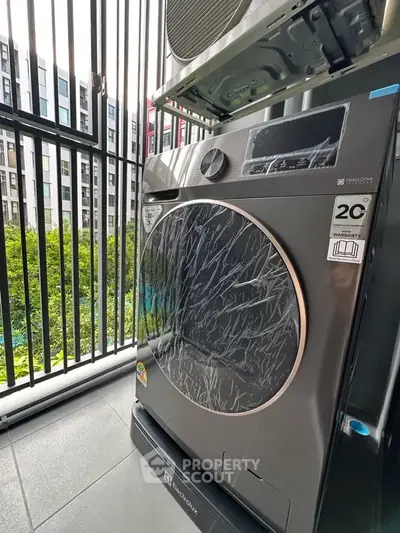 Modern washing machine on a balcony with city view, perfect for urban living convenience.