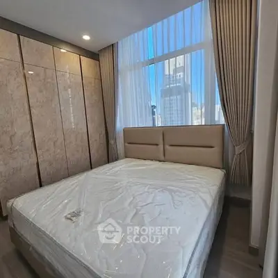 Spacious bedroom with large window and modern wardrobe in urban apartment