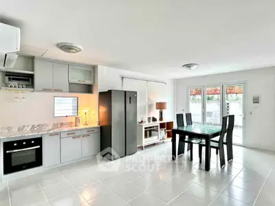 Modern open-plan kitchen and dining area with sleek appliances and natural light.