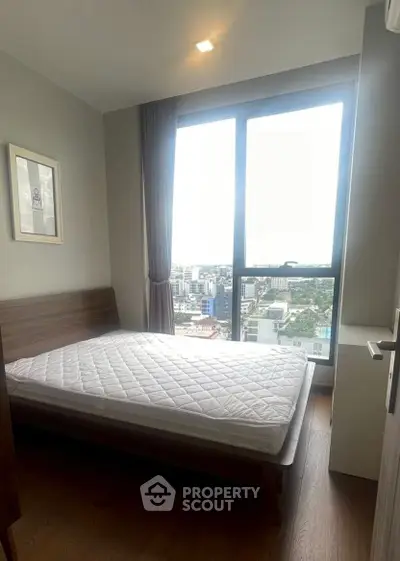 Modern bedroom with large window offering stunning city view