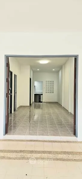 Spacious open-plan interior with tiled flooring and modern kitchen area.