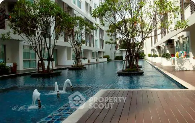 Luxurious condominium pool area with modern design and lush greenery, perfect for relaxation and leisure.