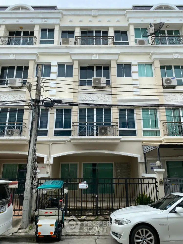 Elegant multi-story residential building with balconies and modern facade in urban setting.