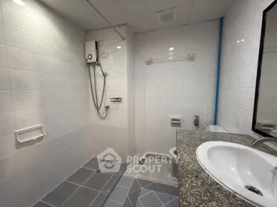 Modern bathroom with shower and granite countertop in a tiled interior