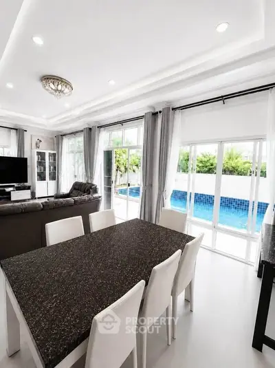 Luxurious open-plan living room with pool view and elegant dining area