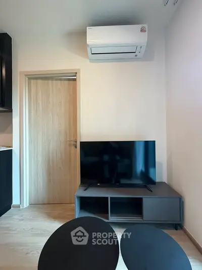 Modern living room with sleek TV setup and air conditioning, perfect for comfortable living.