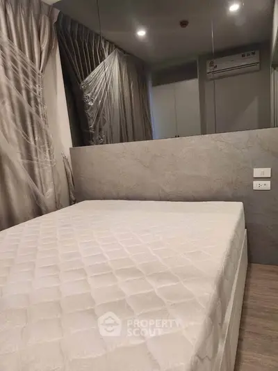 Modern bedroom with elegant curtains and air conditioning unit, featuring a comfortable bed and stylish decor.