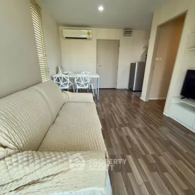 Cozy living room with modern decor and wooden flooring in a stylish apartment.