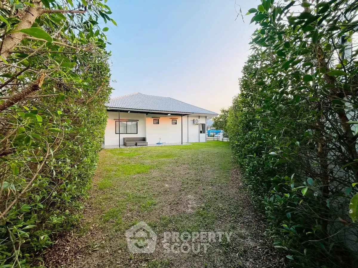 Charming single-story home with lush garden pathway and modern exterior design.