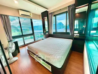 Spacious bedroom with large windows and modern furnishings, offering abundant natural light and a serene atmosphere.