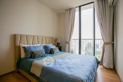 Luxurious bedroom with floor-to-ceiling windows and city view, featuring elegant decor and plush bedding.