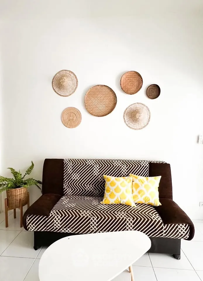 Stylish living room with patterned sofa, decorative wall baskets, and vibrant yellow cushions.