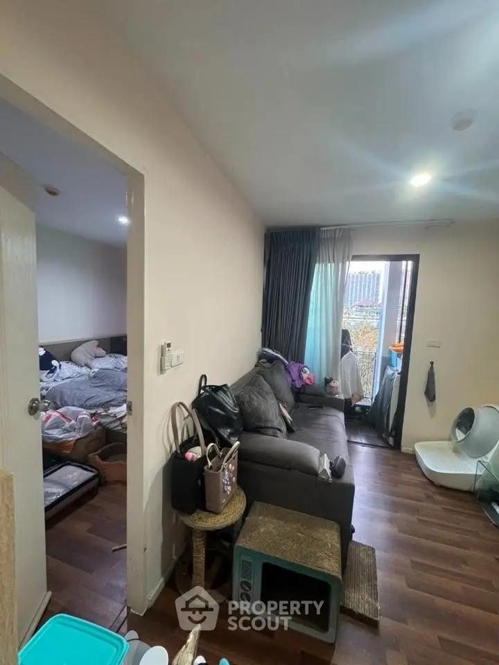 Cozy living room with wooden flooring and balcony access in modern apartment