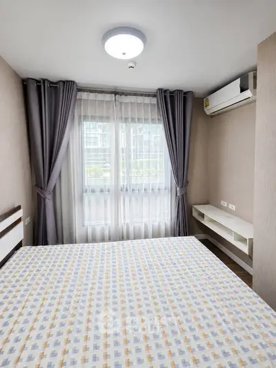 Modern bedroom with large window and air conditioning in urban apartment.