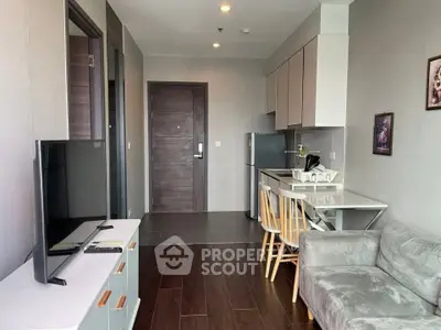 Modern open-layout living room with sleek kitchen and cozy seating area, perfect for urban living.