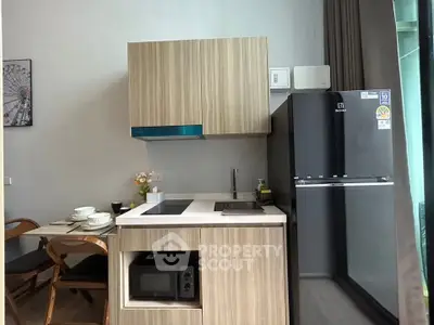 Modern kitchen with sleek cabinetry, built-in microwave, and spacious fridge in a stylish apartment.