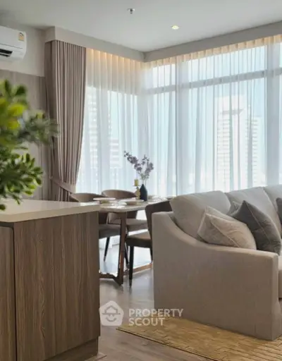 Modern living room with elegant decor and large windows offering city views.