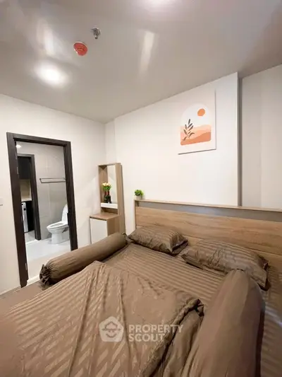 Cozy bedroom with modern decor and ensuite bathroom in stylish apartment.
