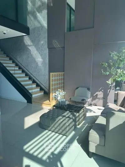 Luxurious modern living room with elegant staircase and natural light