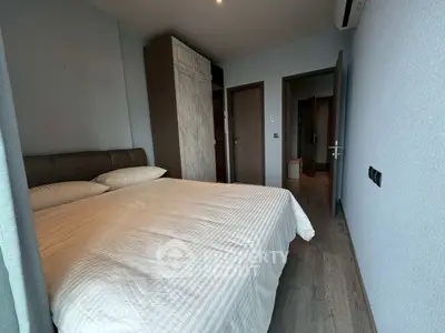 Cozy bedroom with modern decor and ample natural light, featuring a comfortable bed and stylish wardrobe.