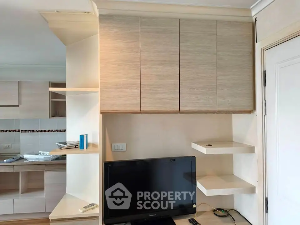 Modern living room with sleek wooden cabinets and flat-screen TV, showcasing contemporary interior design.