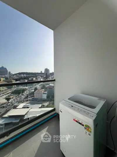 High-rise balcony with city view and washing machine, perfect for urban living.