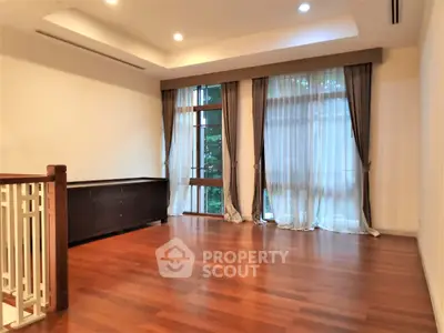 Spacious living room with elegant wooden flooring and large windows for natural light.