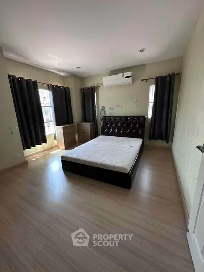 Spacious bedroom with modern design and ample natural light.