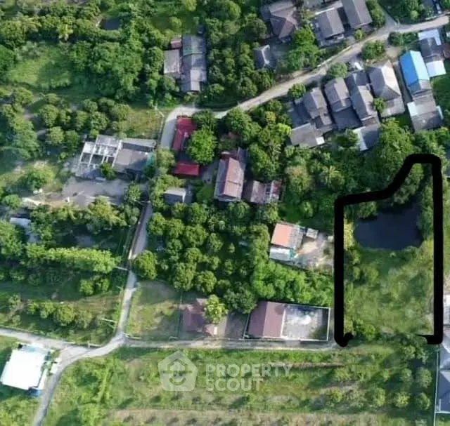 Aerial view of residential area with lush greenery and houses, showcasing potential real estate development.