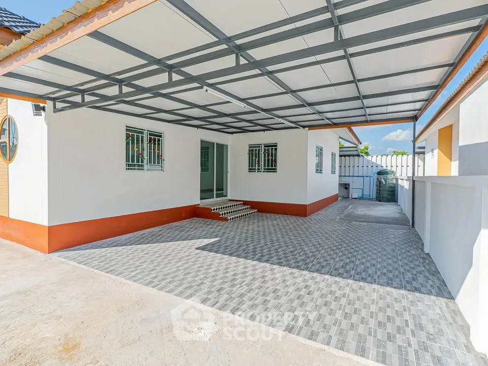 Spacious covered parking area in modern residential property with tiled flooring and secure fencing.