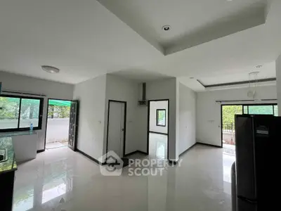 Spacious modern living area with large windows and sleek flooring, perfect for natural light lovers.