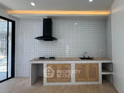 Modern kitchen with gas stove and sleek cabinetry in a stylish open layout.