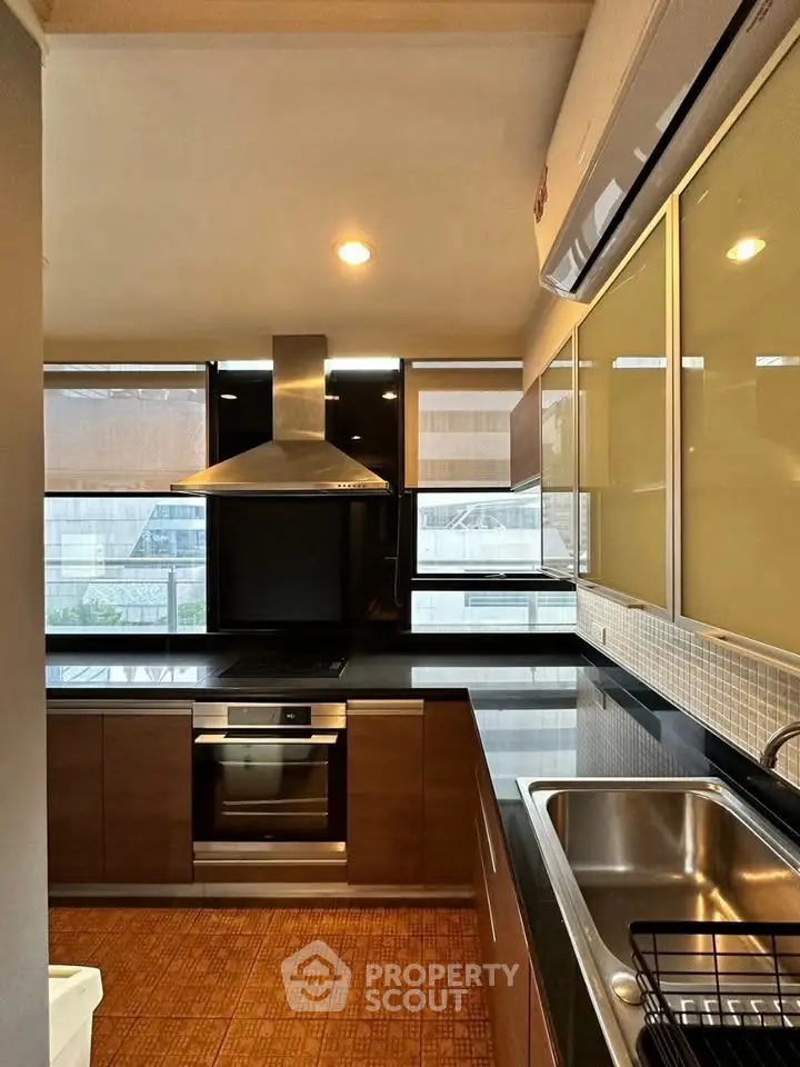 Modern kitchen with sleek cabinetry, stainless steel appliances, and large windows for natural light.