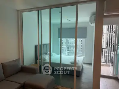 Modern apartment with glass partitioned bedroom and cozy living area.