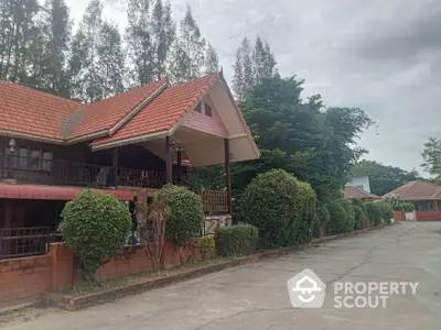 Charming traditional-style homes line a peaceful street, boasting terracotta roofs, lush greenery, and inviting brick fences, perfect for serene living.