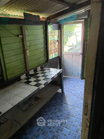 Cozy rustic kitchen with tiled floor and checkerboard countertop, perfect for small spaces.